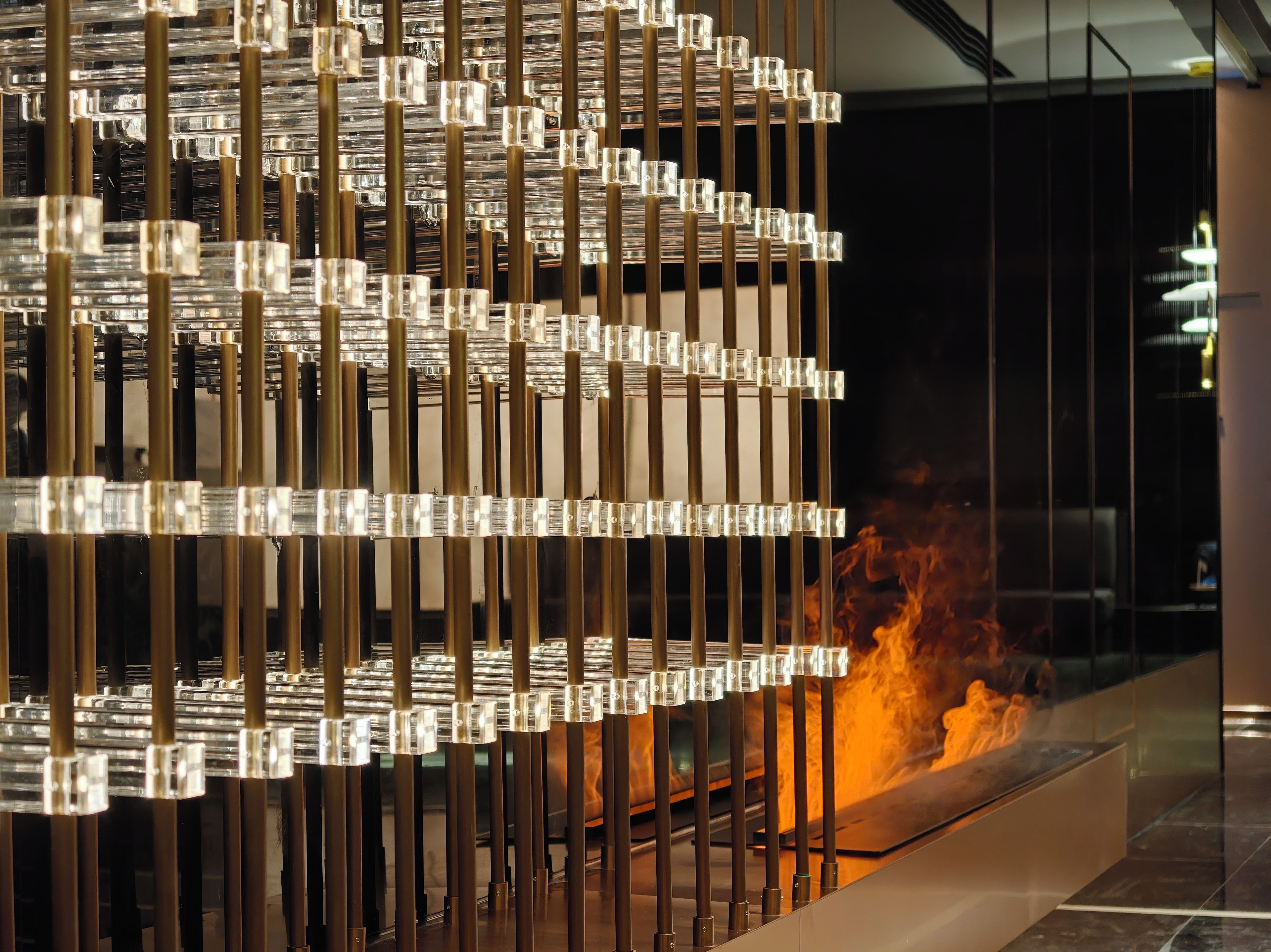 Un interior modern amb una estructura metàl·lica decorativa i una llar de foc visible.