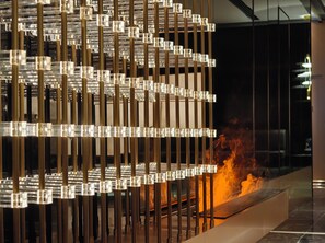 A modern interior with a decorative metal structure and a visible fire feature. - Likto Hotel (Guangzhou)