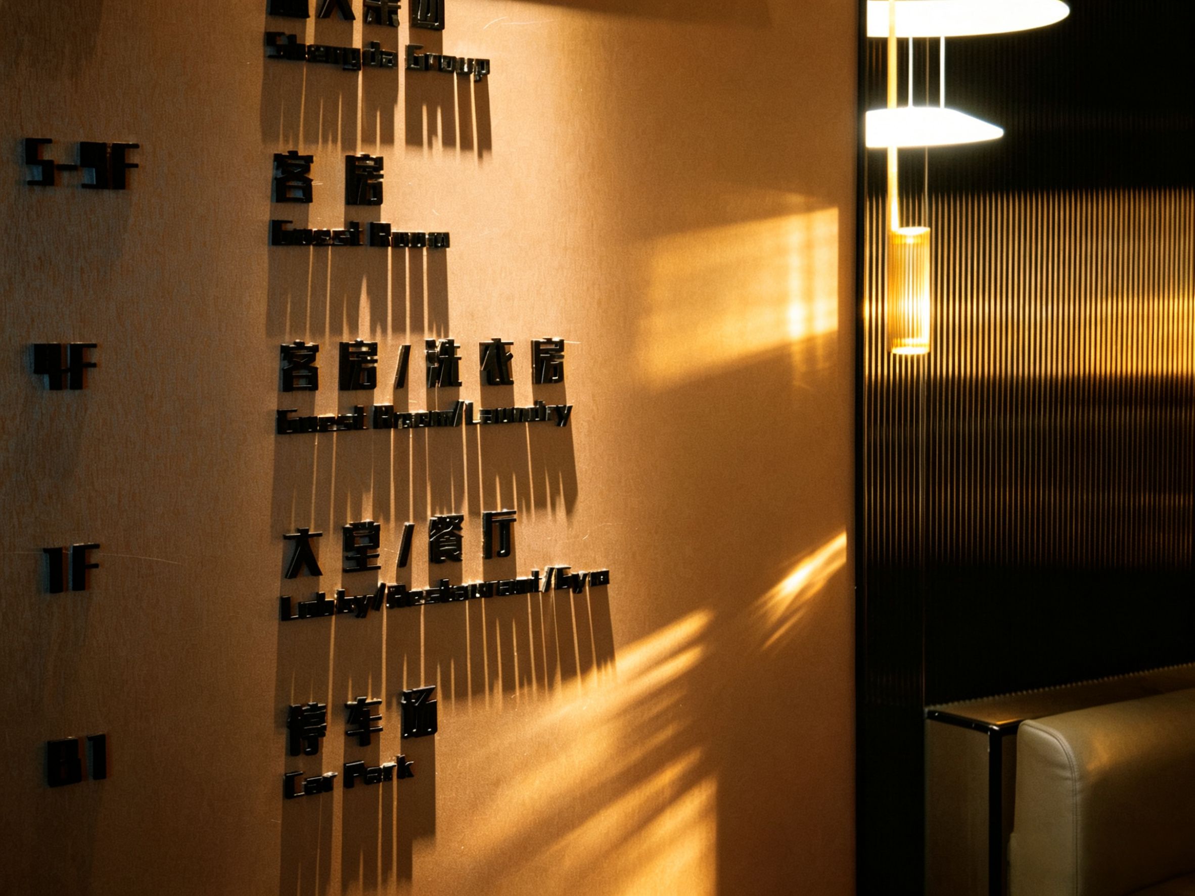 A wall with multiple black signs indicating hotel rooms and a car park.