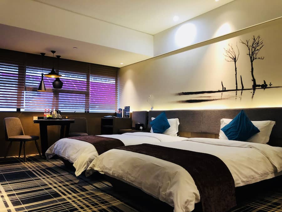 Una habitación de hotel con dos camas, un escritorio y una silla.