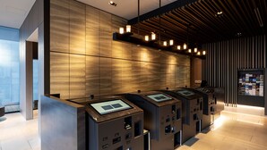 A modern reception area with a wooden wall and a series of ATMs. - remm Tokyo Kyobashi (Tokyo)