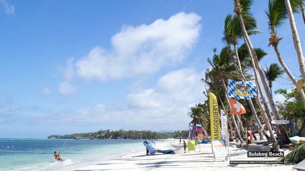 A beach with clear skies, palm trees, and a sign for 'Bulaboog Beach'. - Casa Venicia Caticlan (Malay)