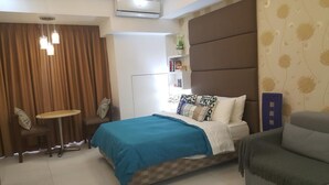 A bedroom with a bed, a desk, a chair, and a bookshelf.