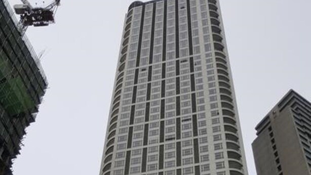 A tall, modern high-rise building with a prominent entrance labeled "Tuh Ocks Place."