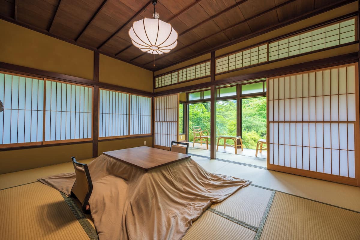 A traditional Japanese room with tatami flooring, a low table, and sliding shoji doors.