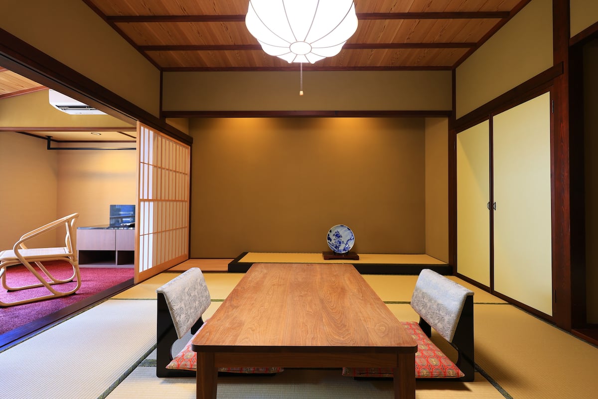 A traditional Japanese room with tatami flooring, a low wooden table, and a shoji screen door.