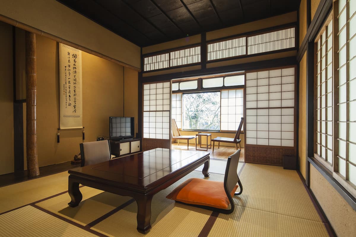 A traditional Japanese room with tatami flooring, a low wooden table, and sliding shoji doors.