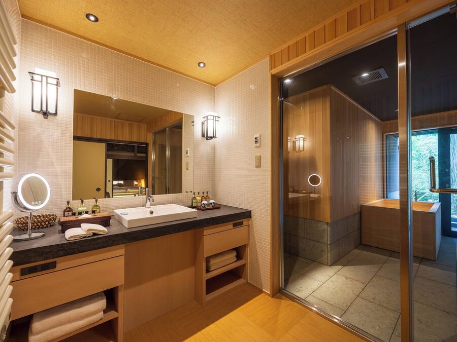 Ein modernes Badezimmer mit einem großen Spiegel, zwei Waschbecken und einer Duschkabine aus Glas.