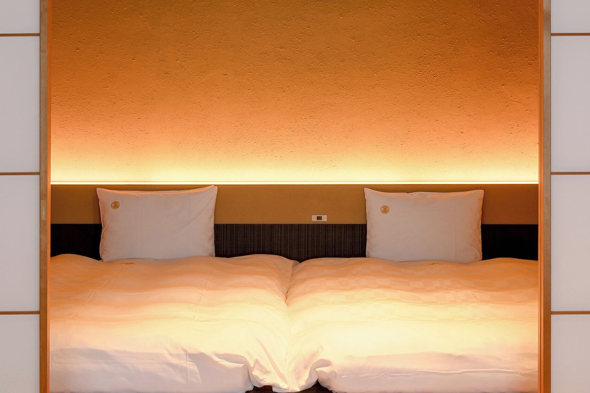 A double bed with a headboard that has a textured wall behind it.