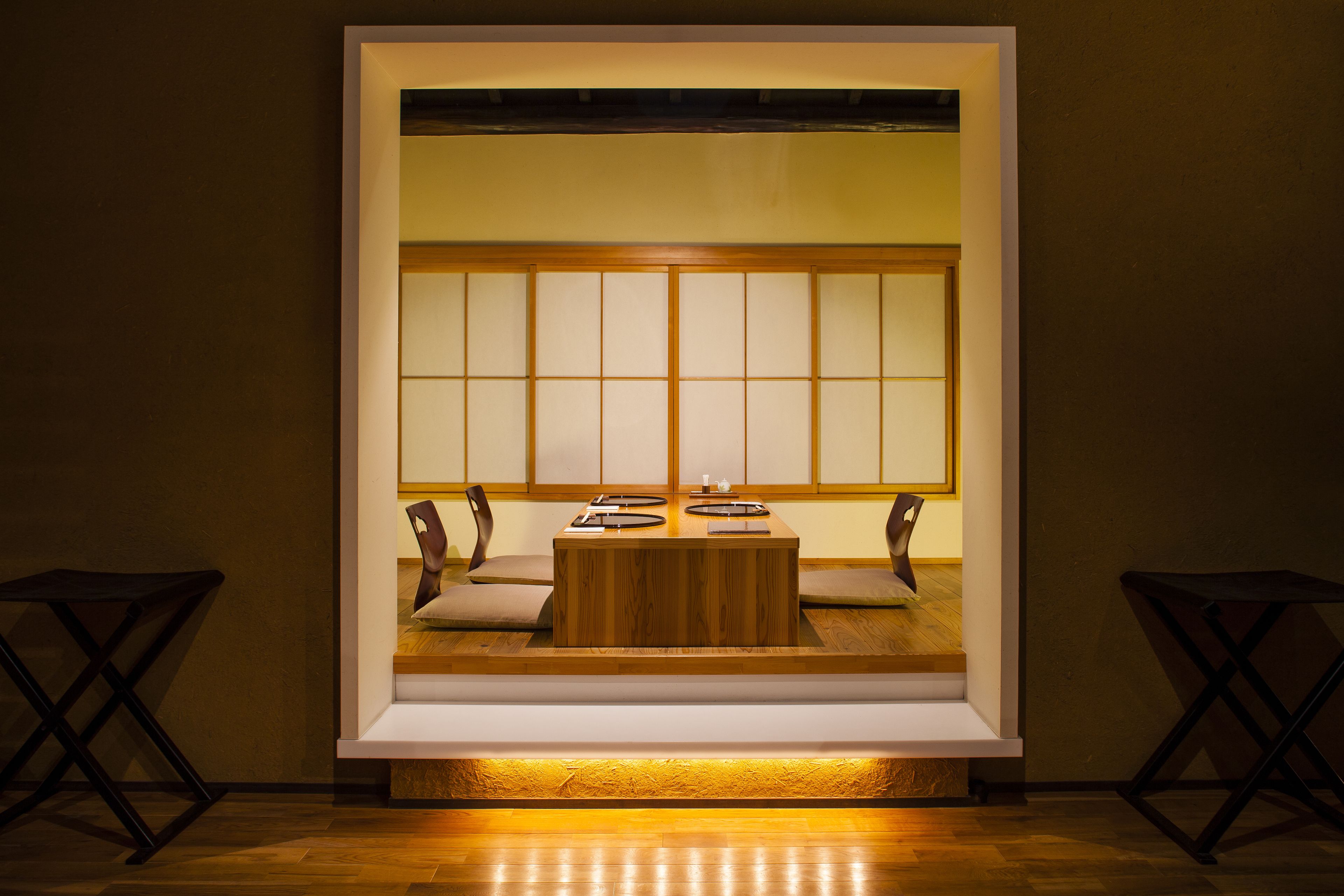 A traditional Japanese room with tatami mat flooring, a low wooden table, and a sliding shoji screen door.