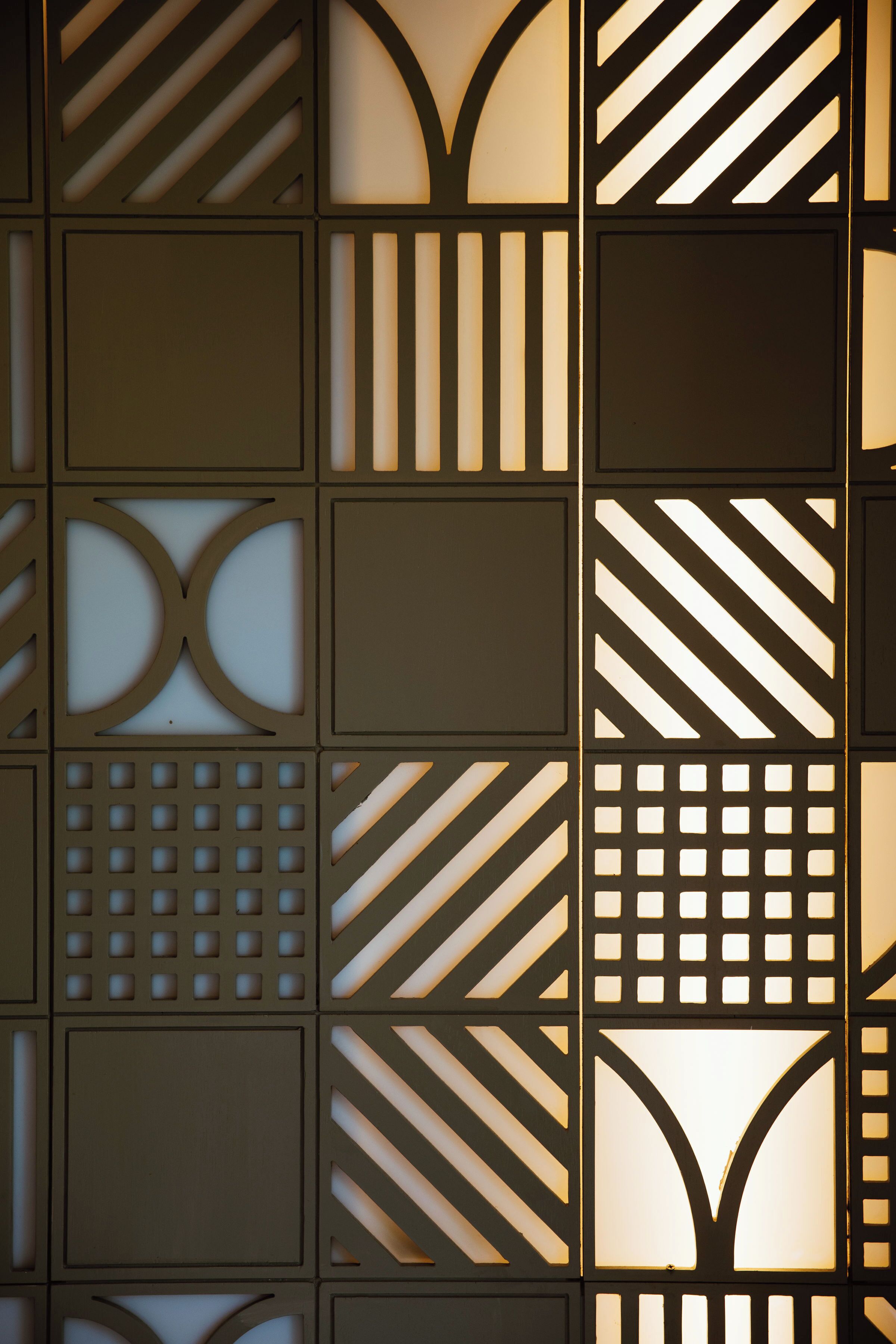 Una pared con patrones geométricos y diseños recortados.