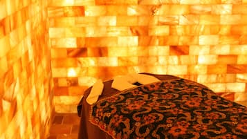 A room with a woven wall and a bed with a patterned bedspread.