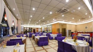 A banquet hall with round tables, purple chairs, and white tablecloths. - Shi Dai Jin Cheng Hotel (Chengdu)