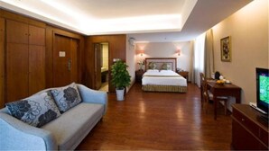 A hotel room with a bed, a sofa, a television, and a desk. - Shi Dai Jin Cheng Hotel (Chengdu)