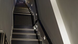 A staircase with a black and white color scheme, metal handrails, and a patterned floor.