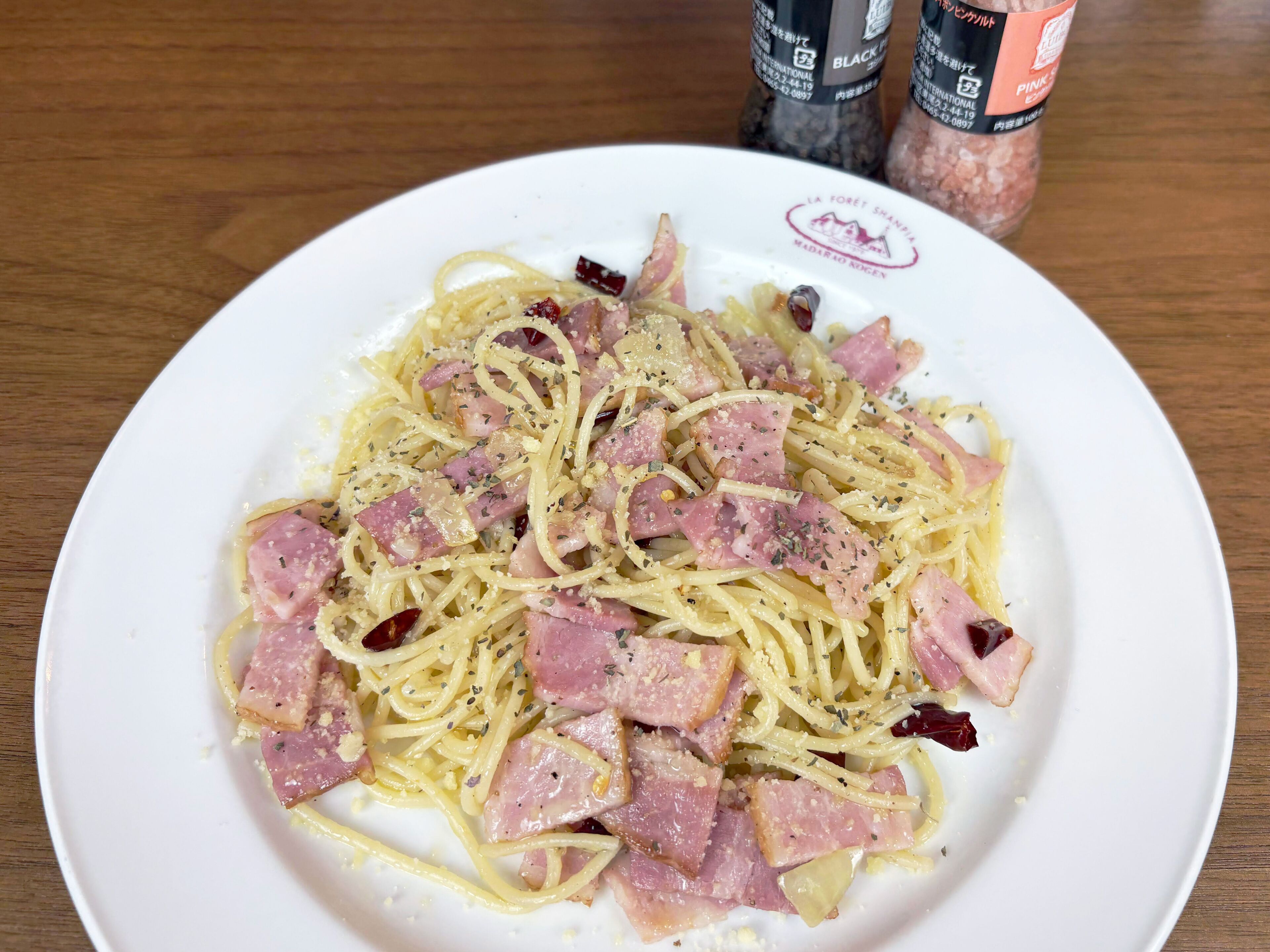 Een bord spaghetti met ham en kaas.