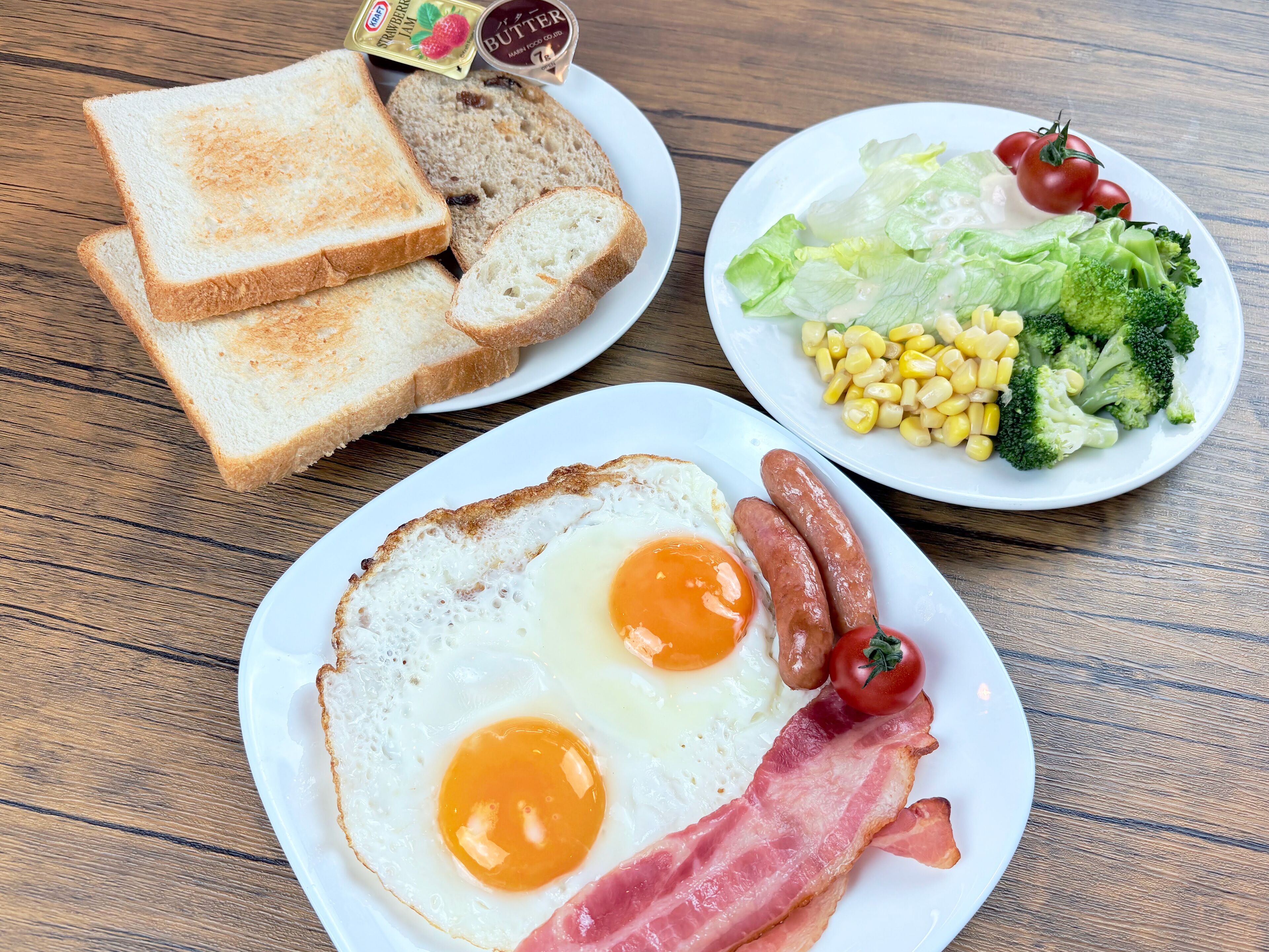 Une assiette de petit-déjeuner avec des toasts, des œufs, des saucisses et du bacon.