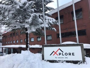 Un bâtiment sur lequel on peut lire l’inscription « PLORE by active life », entouré de neige.