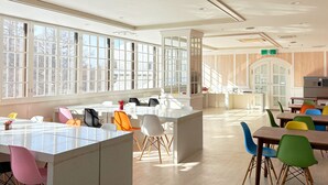 Un comedor amplio con ventanas grandes, una isla central y varias opciones de asientos.