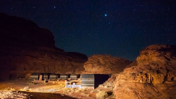 Un hotel en el desierto con varias habitaciones bajo un cielo estrellado.