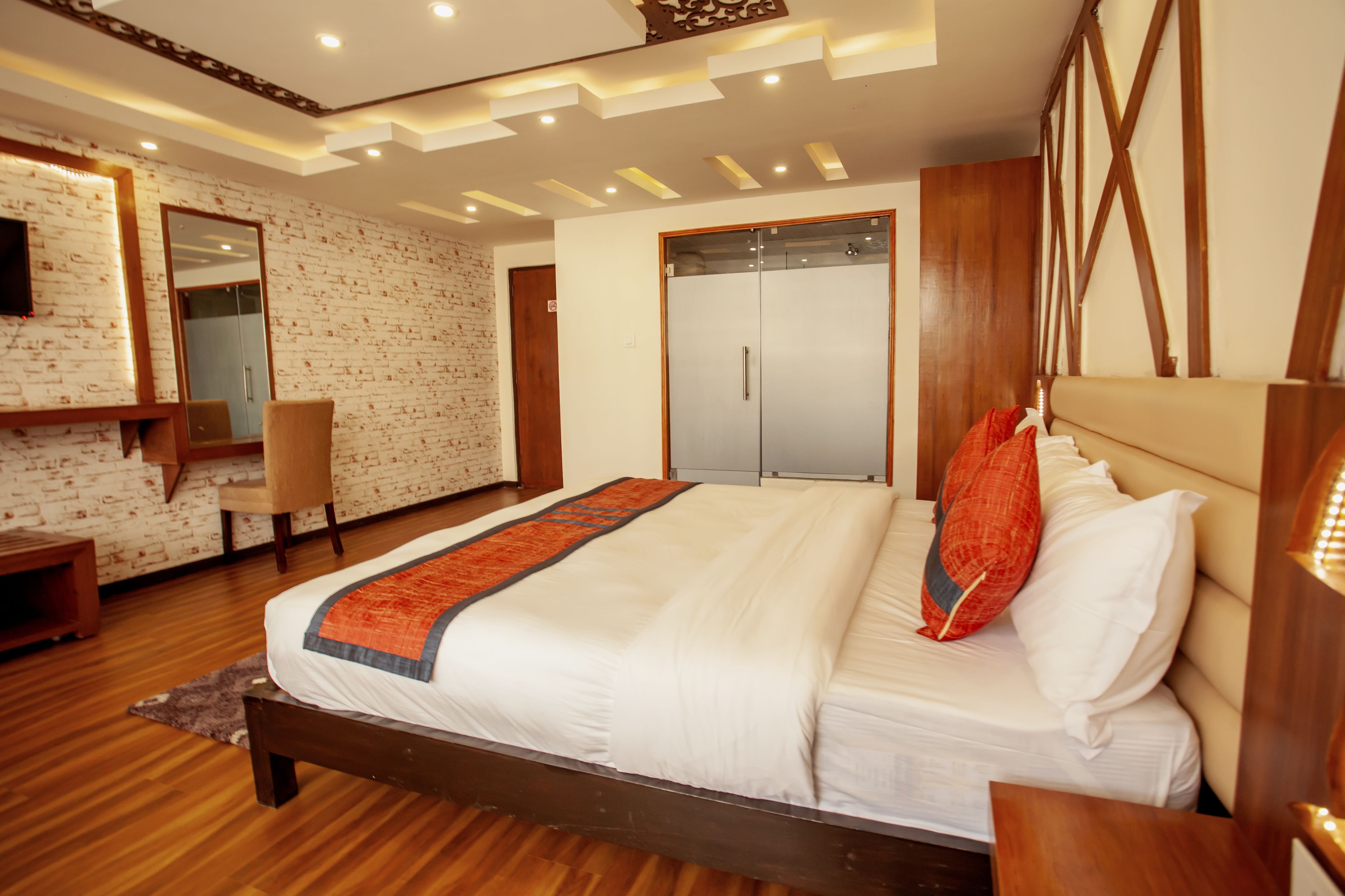 Un dormitorio moderno con una cama de madera, un espejo grande, un armario y un escritorio.
