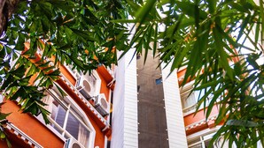 A multi-story building with a central vertical feature, possibly a lobby or atrium, surrounded by balconies and windows. - Hotel Jampa (Kathmandu)