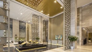 A modern lobby with a reception desk, seating area, and decorative lighting. - Meliá Vinpearl Thanh Hoa (Hac Thanh)