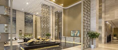 A modern lobby with a reception desk, seating area, and decorative lighting.