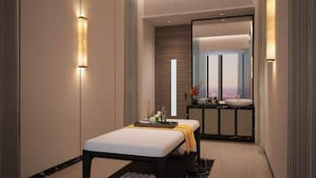 Un spa moderno con una camilla de masaje, un tocador con un espejo grande y vistas a la ciudad a través de la ventana.