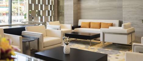 A modern living room with a sofa set, a coffee table, and a decorative vase.