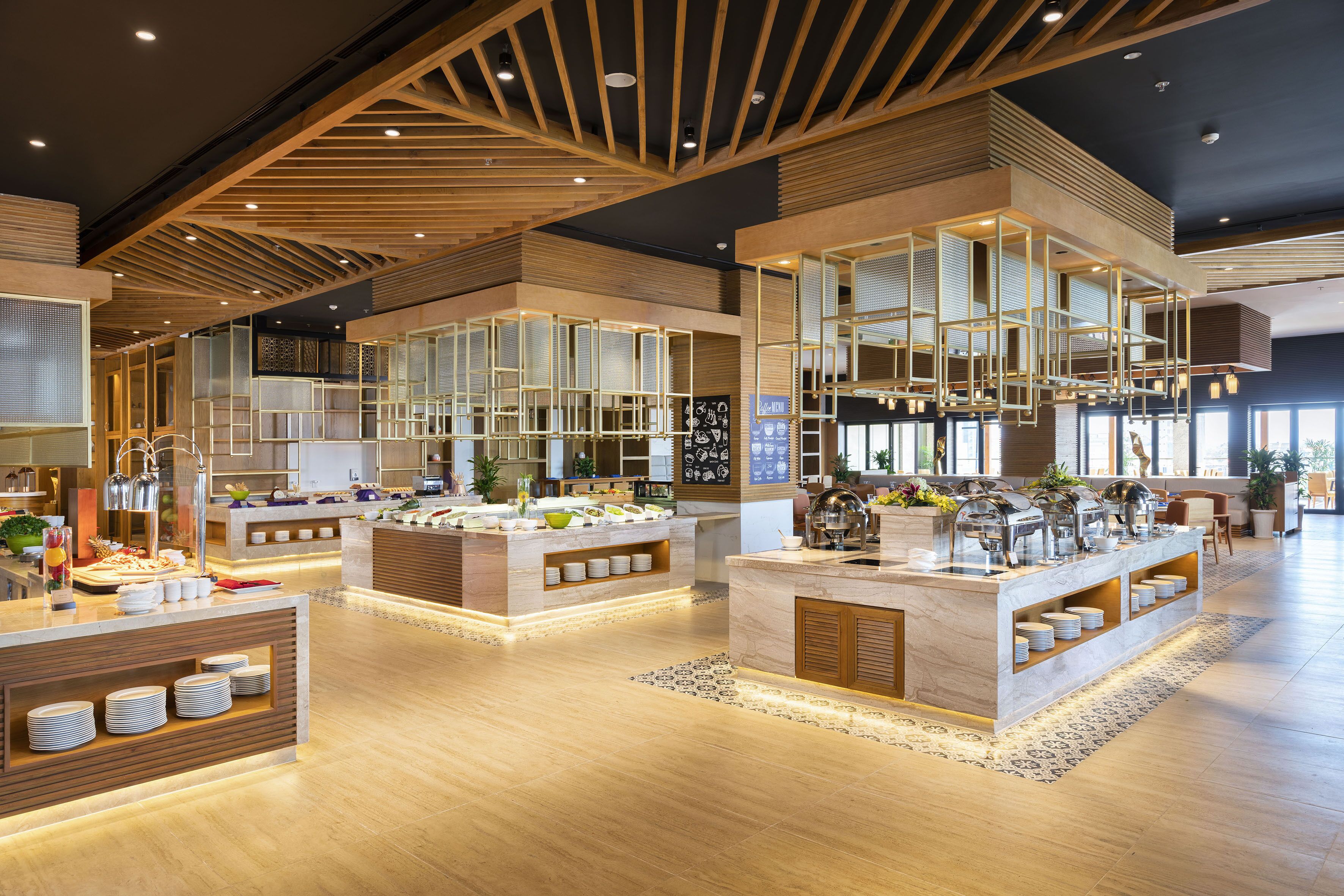 Un hall d’hôtel moderne doté d’un espace buffet central, d’un plafond en bois au design original et d’une disposition spacieuse.