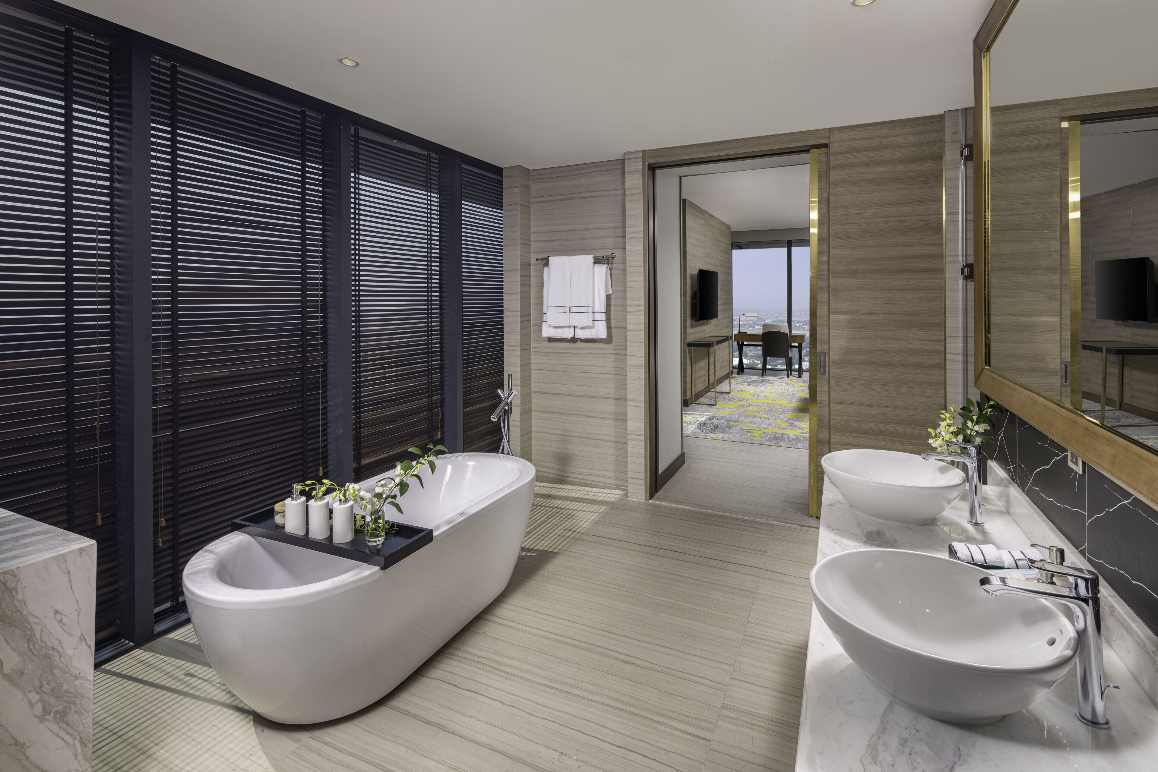 A modern bathroom with a freestanding bathtub, a double sink vanity, and a large mirror.