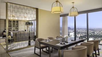 Un moderno comedor con vistas a la ciudad, que incluye una mesa grande, sillas cómodas e iluminación elegante.