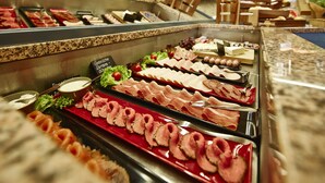Un buffet proposant une variété de viandes et de fromages.