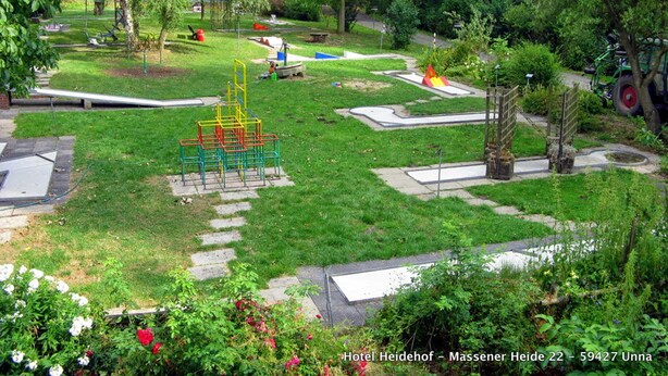 A park with playground equipment, walking paths, and a garden area. - Hotel Heidehof (Unna)