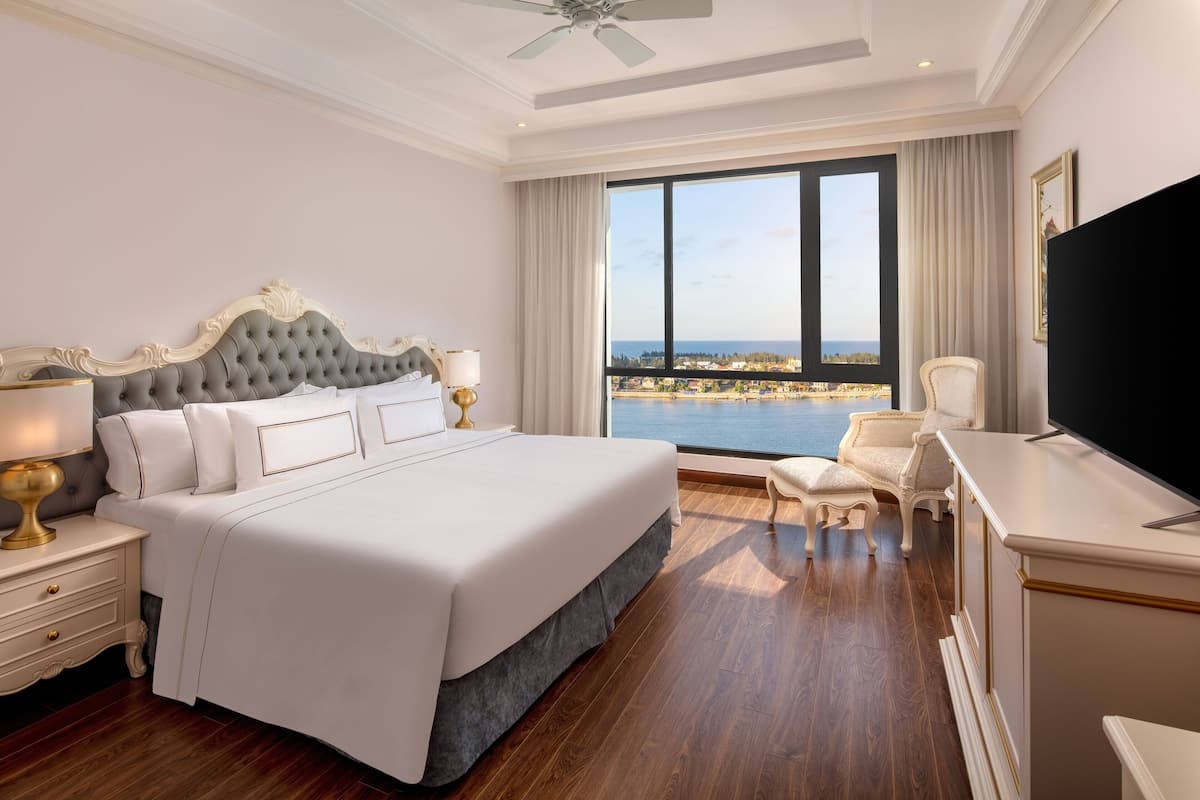 A spacious bedroom with a large bed, a desk, and a chair.
