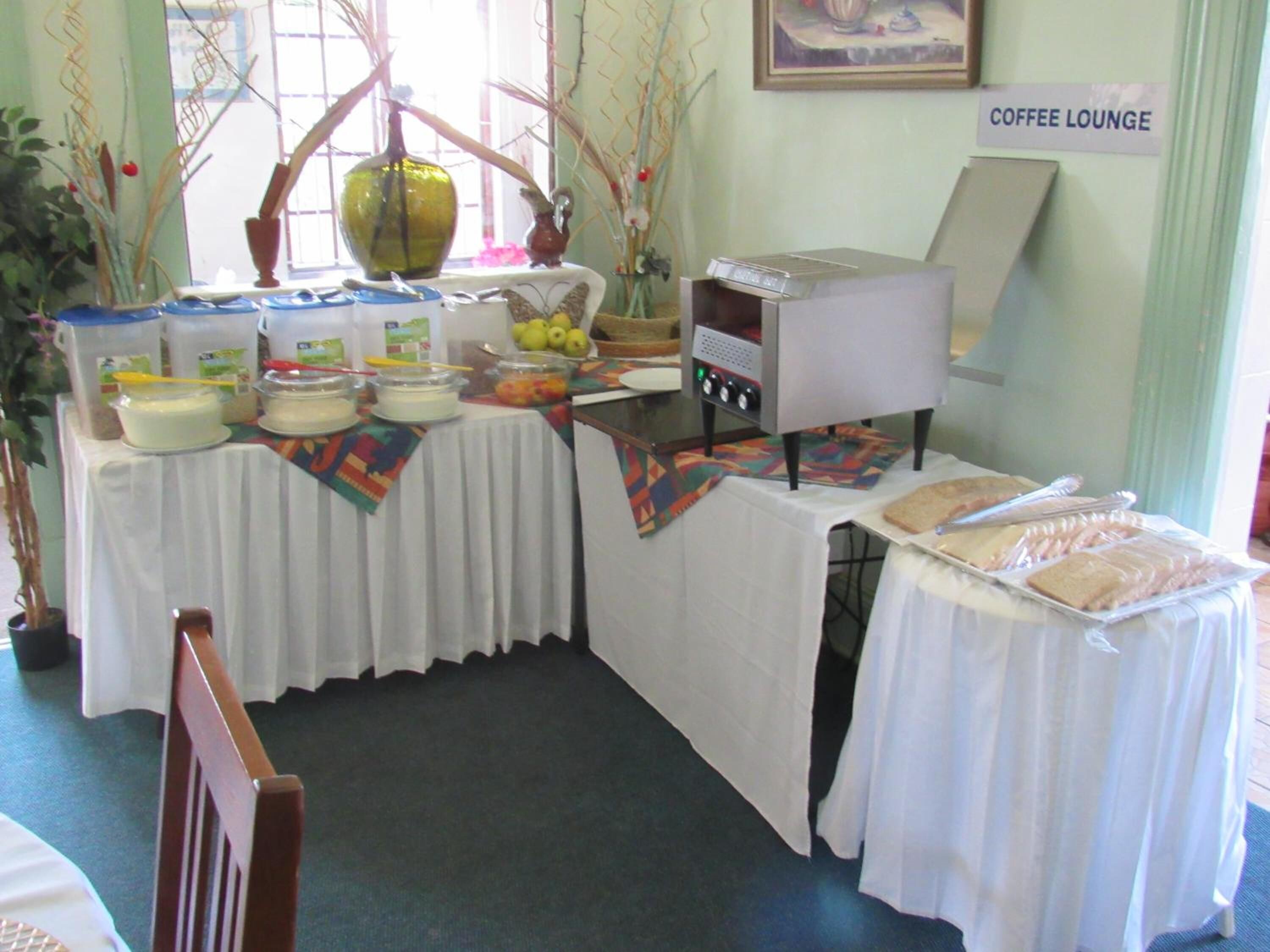 A coffee lounge area with a buffet table, a coffee machine, and a sign indicating the coffee lounge.