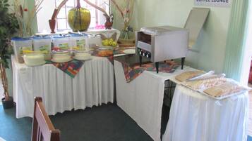 Un'area lounge con tavoli per il caffè, un buffet, una macchina da caffè e una segnaletica che indica il caffè.