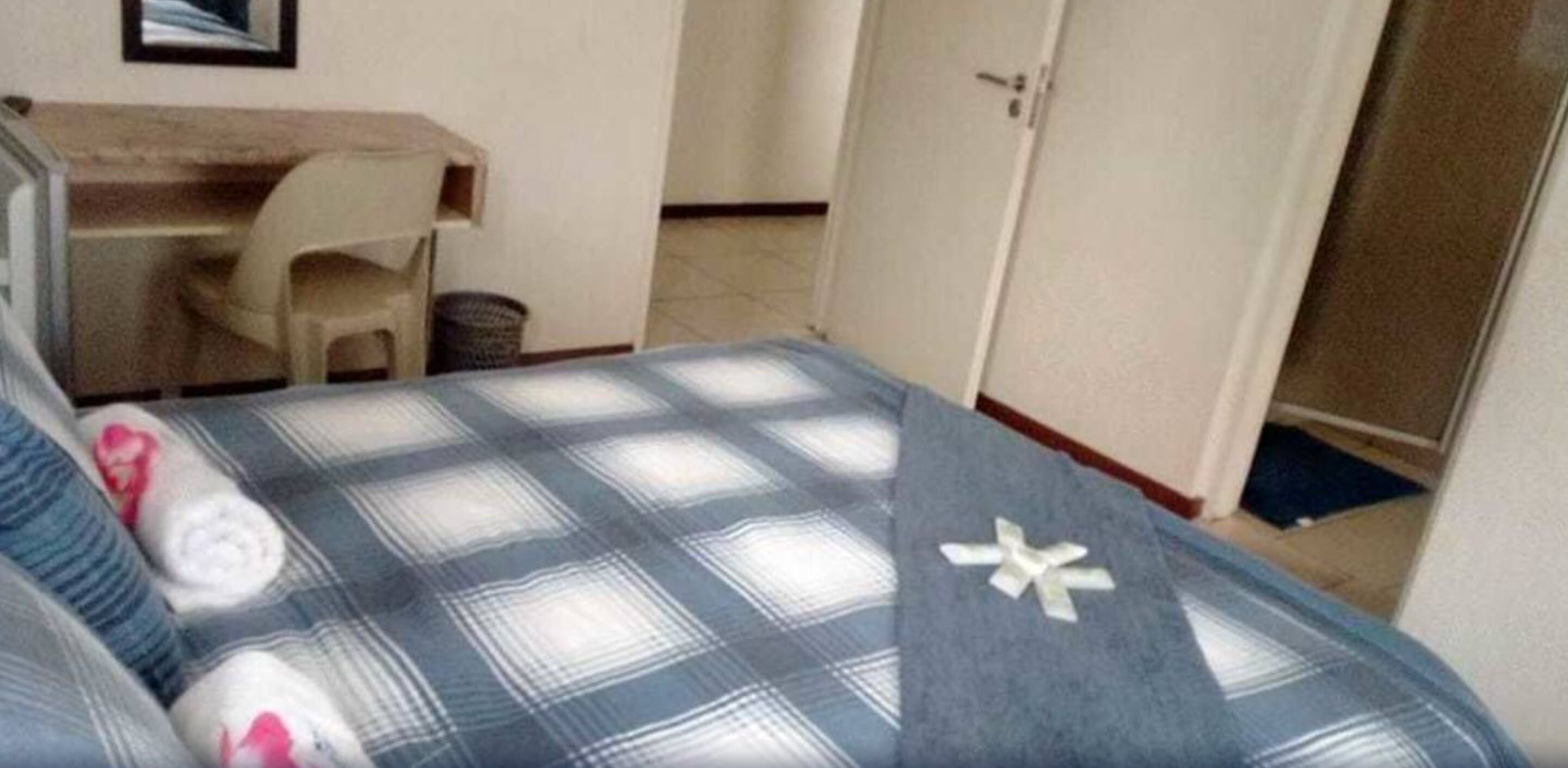 A bedroom with a bed, a desk, and a chair.