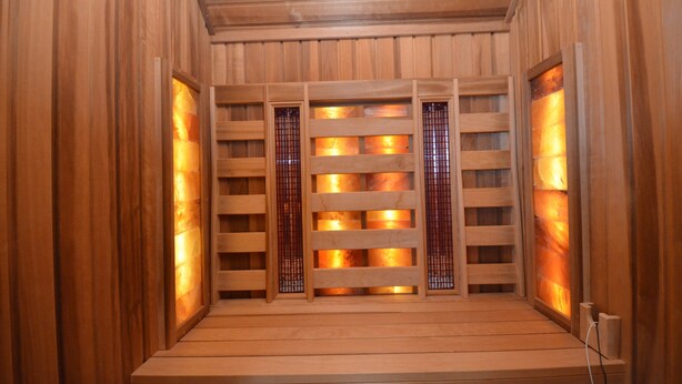 Un sauna en bois avec un mur en bois à lattes et un banc.