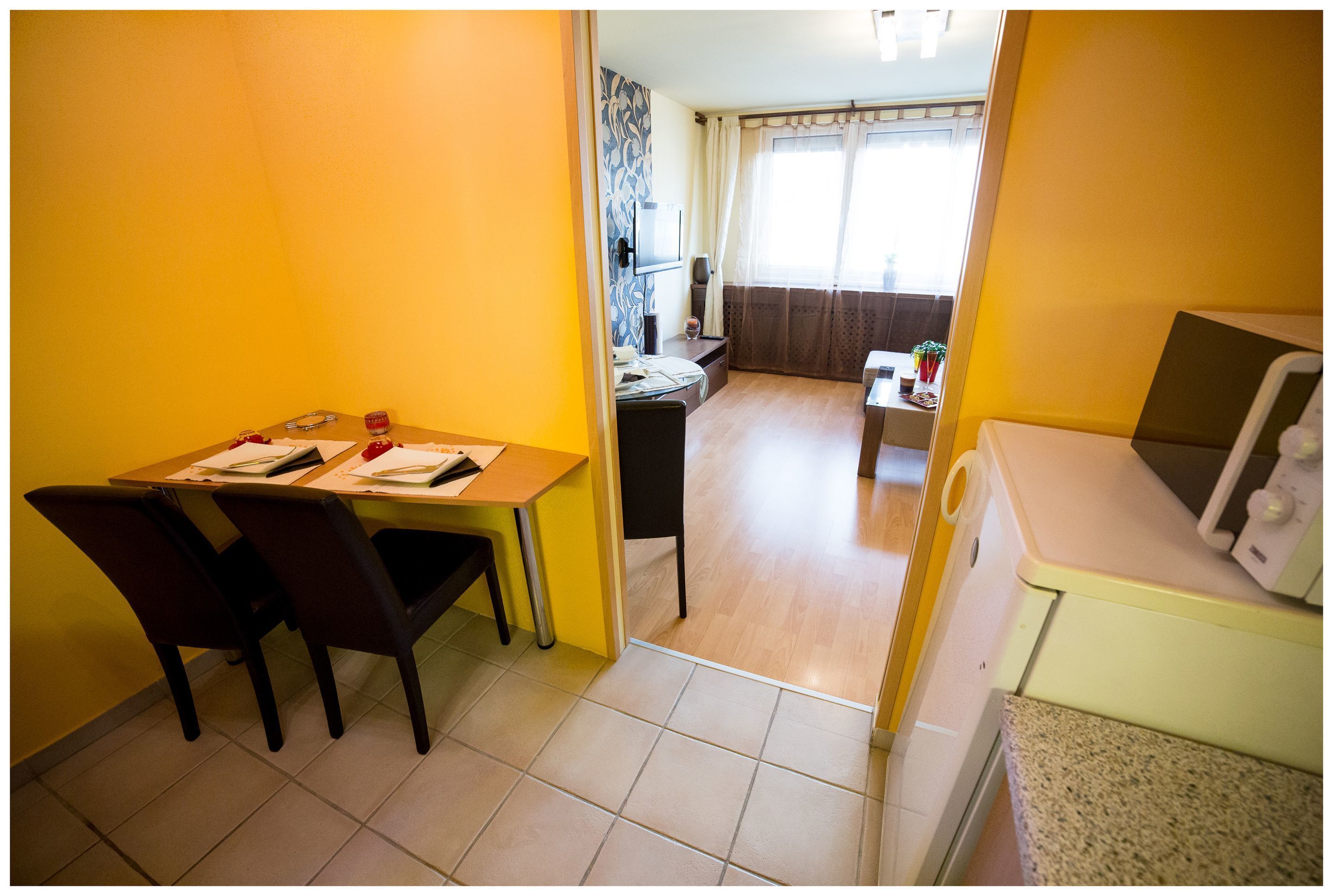 A compact living space with a dining area, kitchenette, and a small living room.