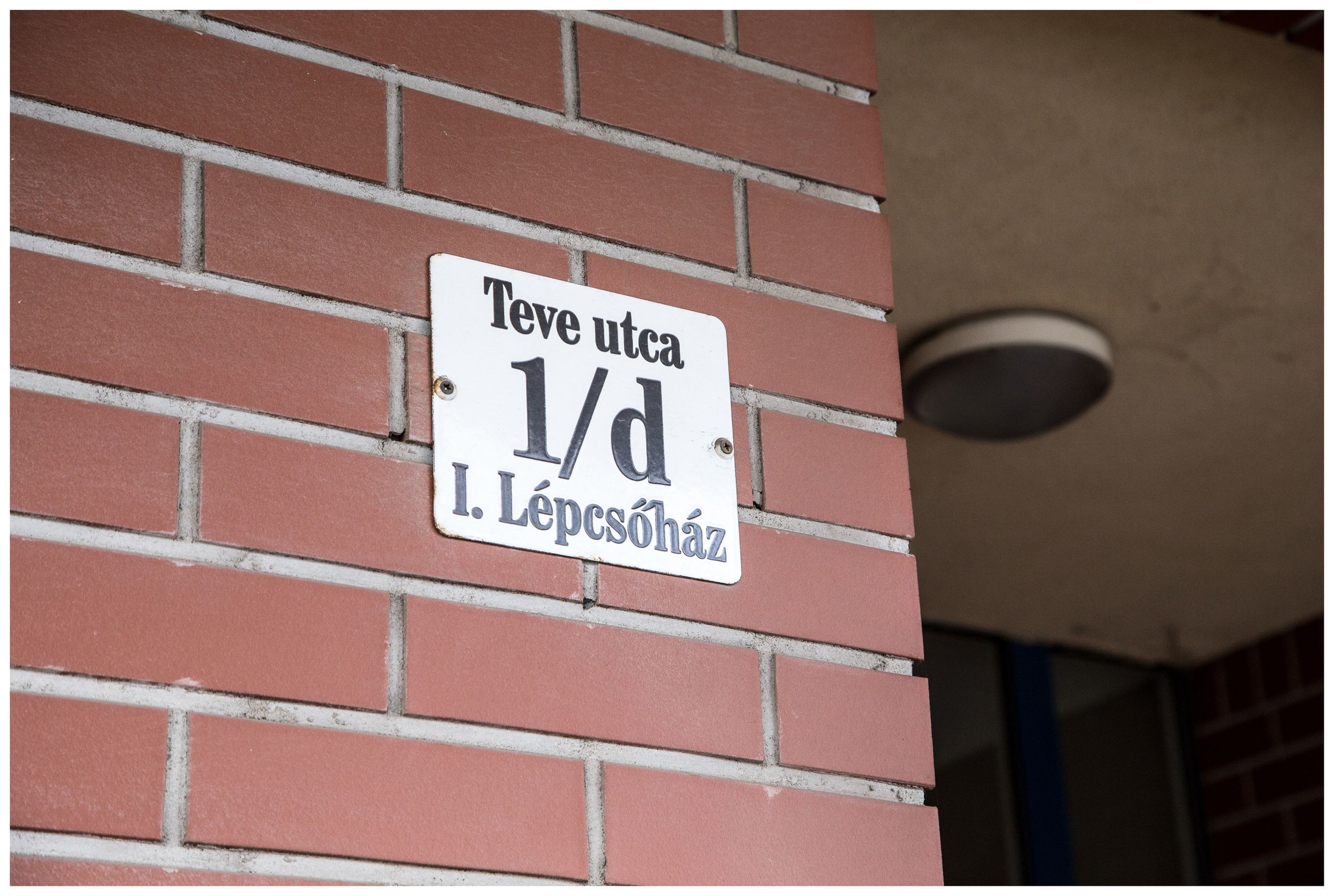 A sign on a brick wall with the text "Teve utca 1/d I. Lépcsöház".