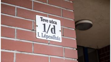 A sign on a brick wall with the text "Teve utca 1/d I. Lépcsöház".