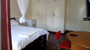 A bedroom with a bed, a wardrobe, a desk, and a chair. - Kadana Bed & Breakfast - Adults Only (Nairobi)