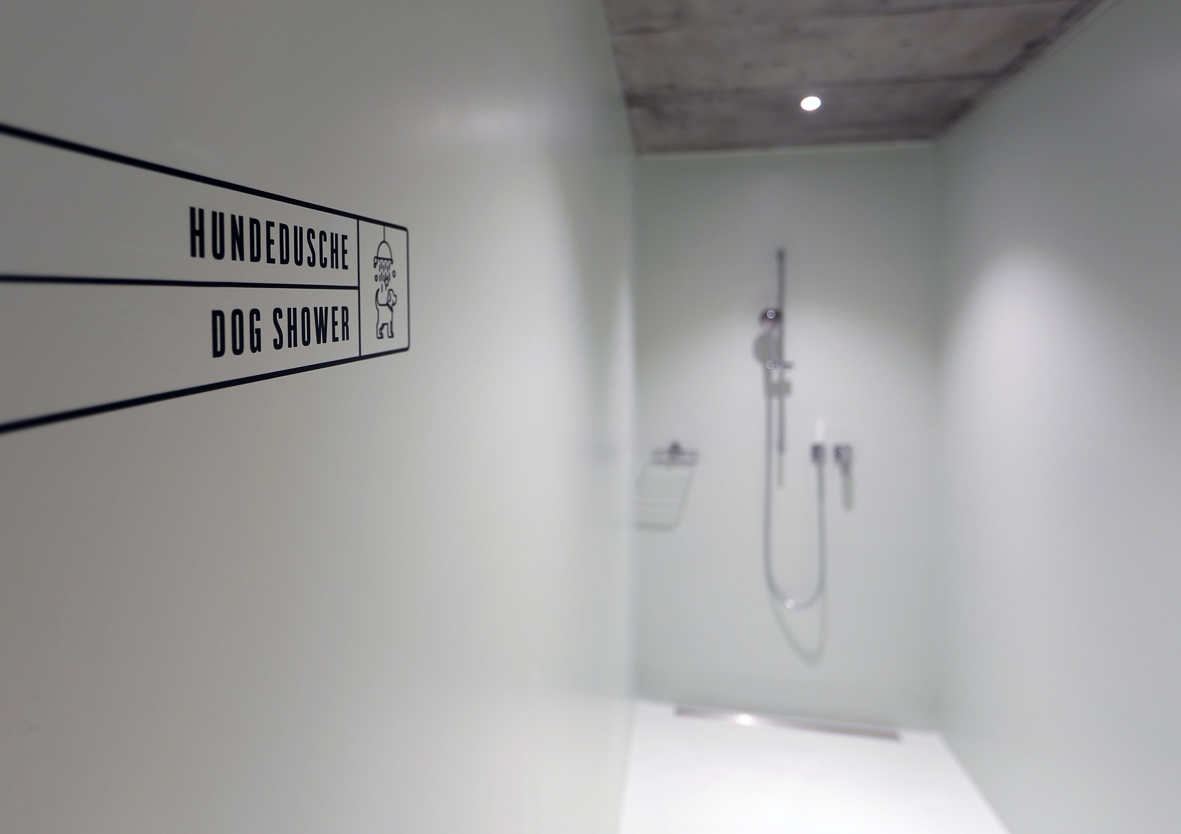 A bathroom with a sign indicating a dog shower.