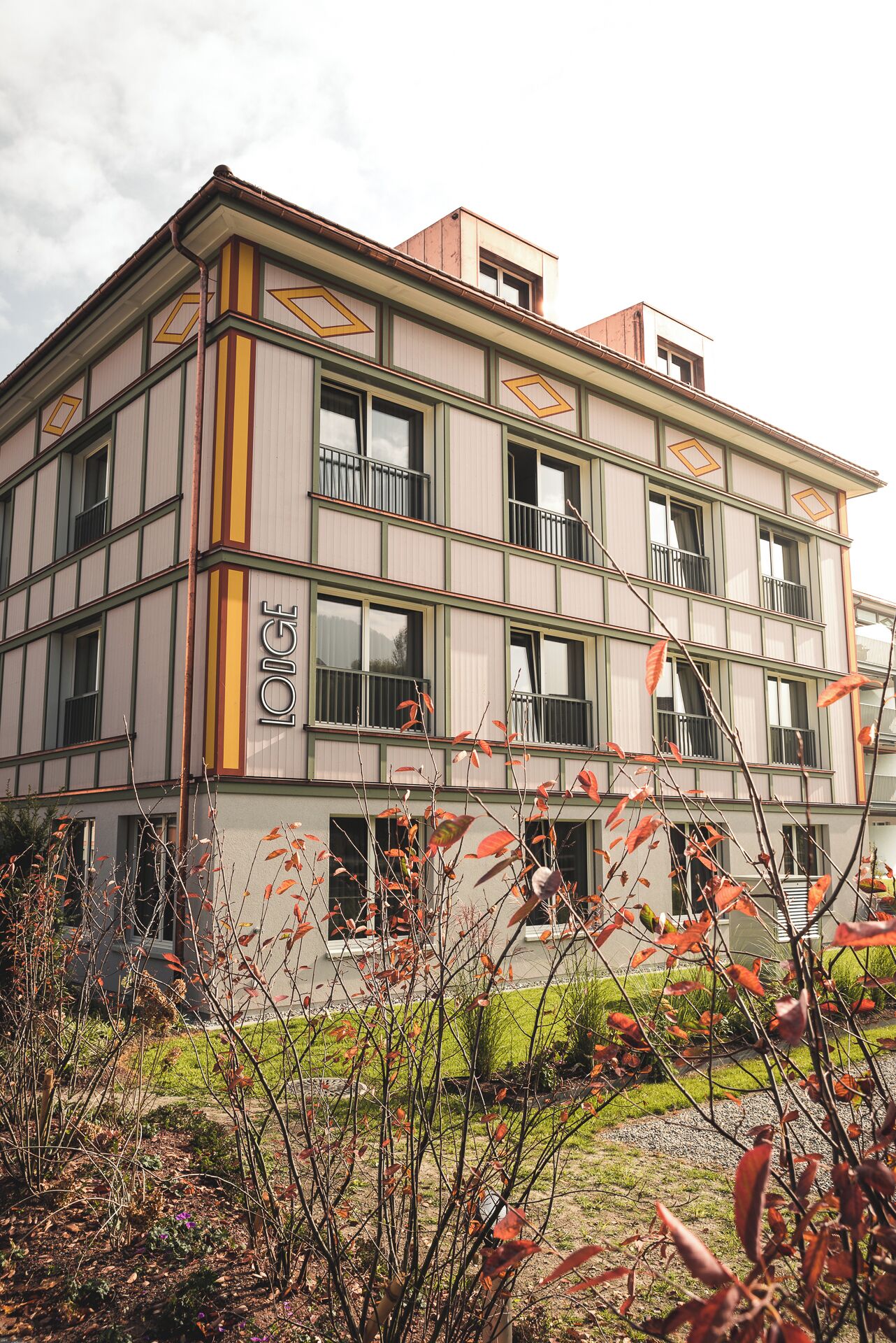 Un immeuble à plusieurs étages doté d’une façade symétrique, de grandes fenêtres et d’une enseigne bien visible portant l’inscription « LOIGE ».