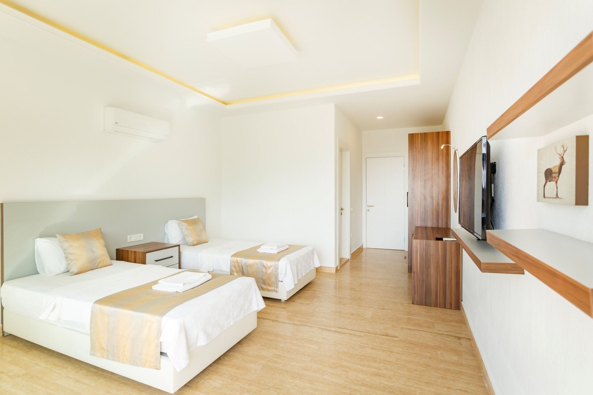 A hotel room with two beds, a TV, and a wooden cabinet.