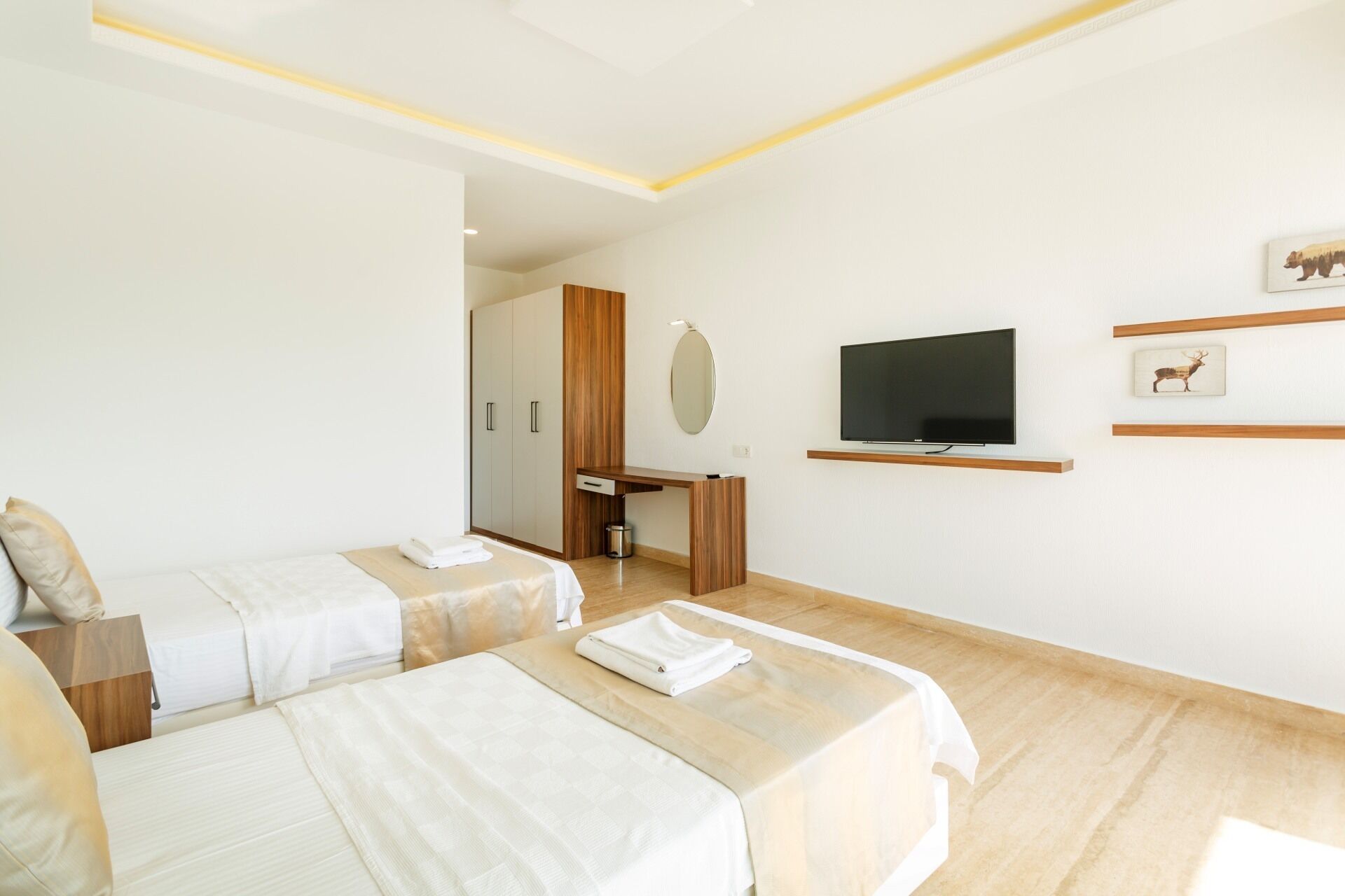A hotel room with two beds, a TV, a desk, and a wardrobe.