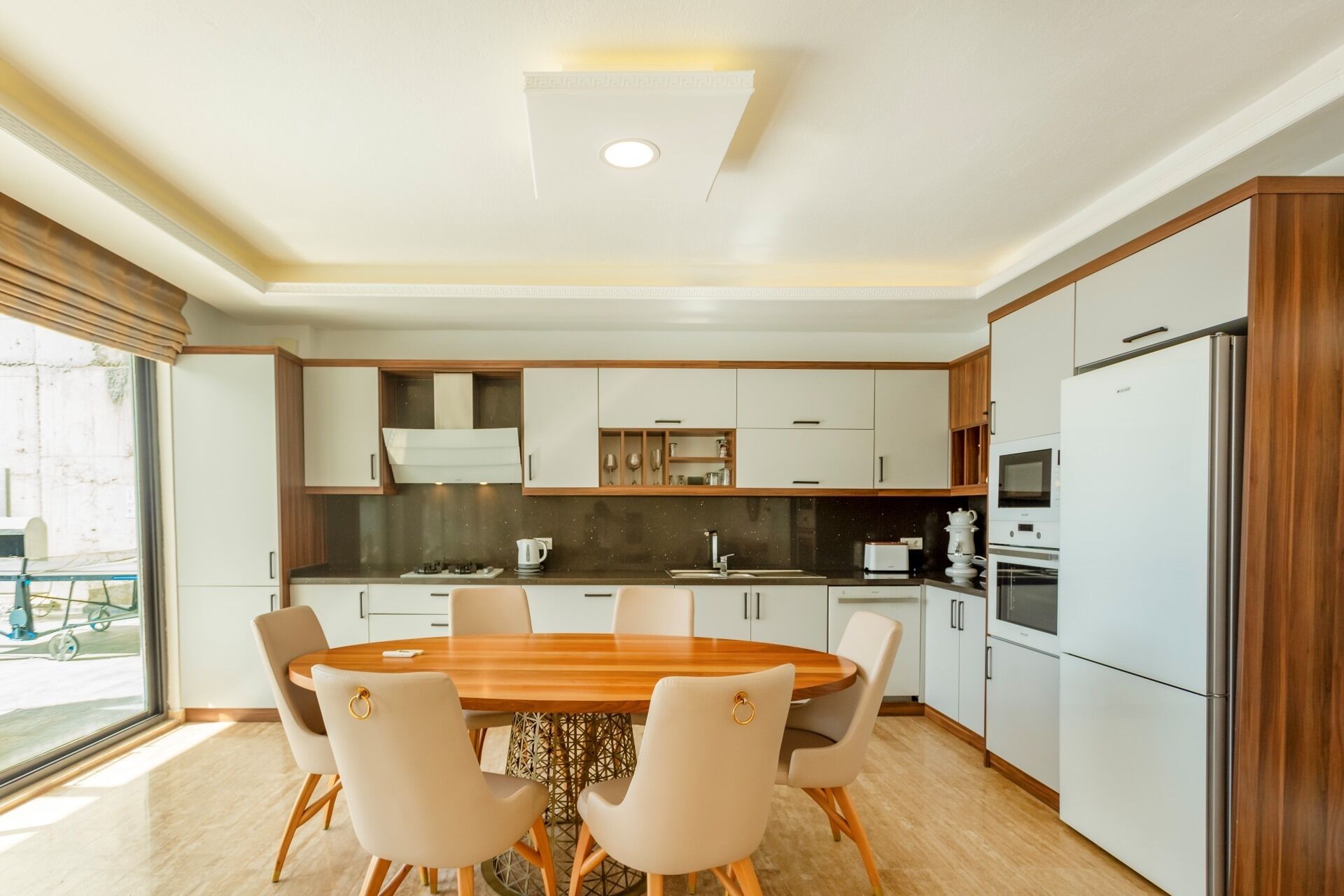 A modern kitchen with a central island, white cabinets, and a built-in oven.