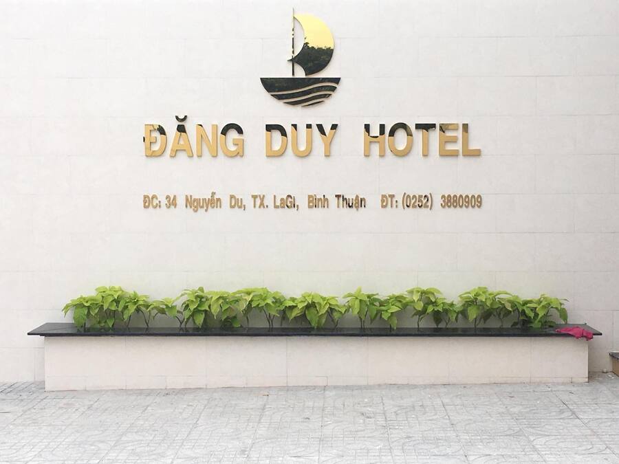 Señal de ĐÀNG DUY HOTEL con logotipo de velero, dirección y número de contacto.